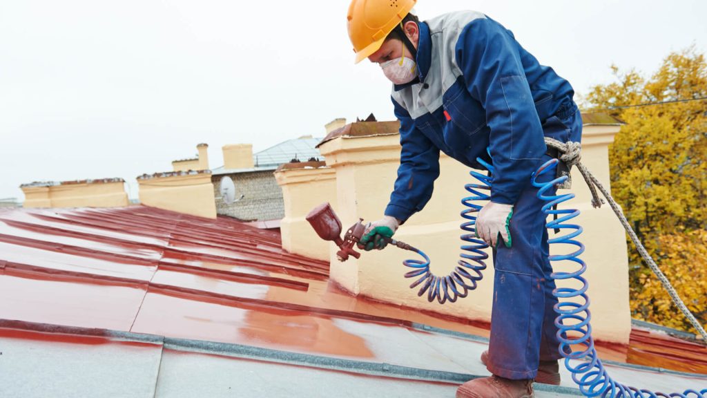 Image of a man painting a roof top