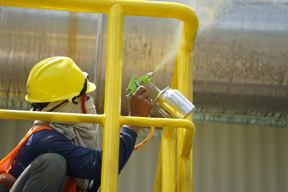 Spray painting Yellow color to the steel by the worker